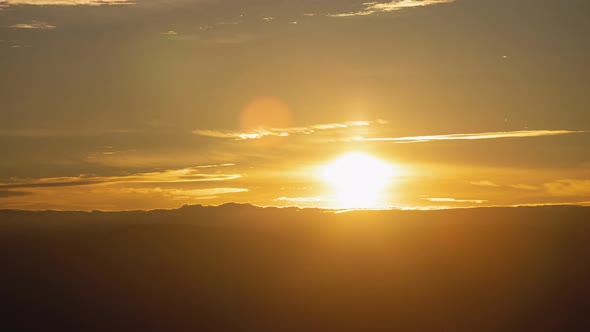 Golden Sunrise Behind Thin Layer of Clouds Wide Shot Timelapse