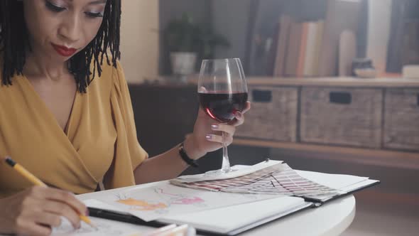 Woman Having Wine and Drawing Fashion Sketches alt