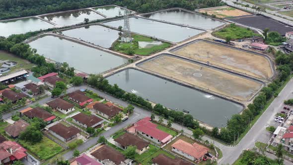 Drone flyover residential neighborhood in manjung, birds eye view overlooking at surrounding aquacul alt