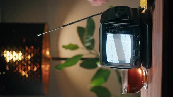 Vertical Video of Turning on Small Old Television with Grey Interference Screen on Home Background alt