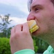 Stubble Guy Bites Off Chews Sandwich in the City Park - VideoHive Item for Sale
