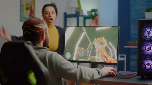 Nervous Woman Screaming at Husband While He is Playing Videogame alt