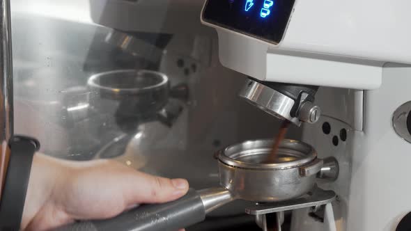 Cropped Shot of a Barista Grinding Coffee in Coffee Machine