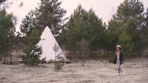 Young Nice Woman Walking Through Countryside to Glamping Outside Teepee