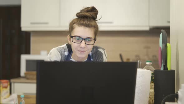 Beautiful Women Smile and Cooking with Online Muffins Recipes From Laptop at Home alt