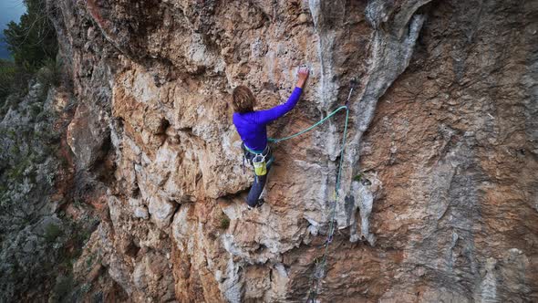 Strong Girl Rock Climber Climbs on Overhanging Crag alt