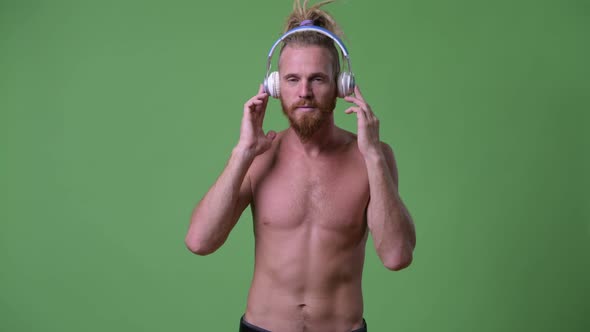 Handsome Muscular Bearded Man with Dreadlocks Listening To Music Shirtless alt