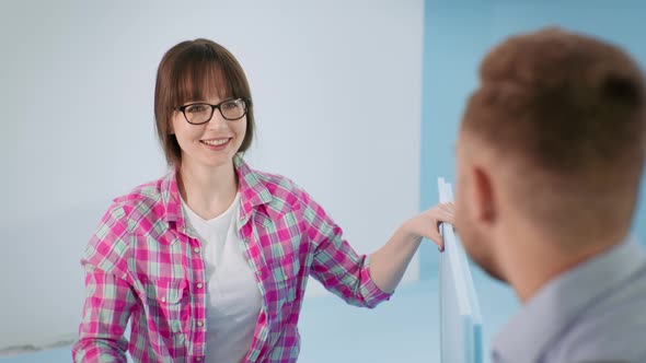 Woman with Glasses for Eyesight with Male Builder Discussing Building Material for Floor Insulation alt