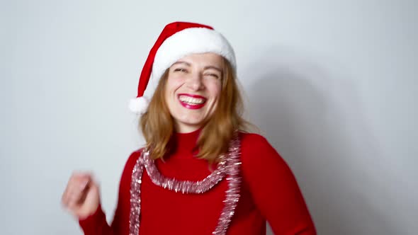 Happy woman dancing in Santa Claus hat in a festive mood. alt