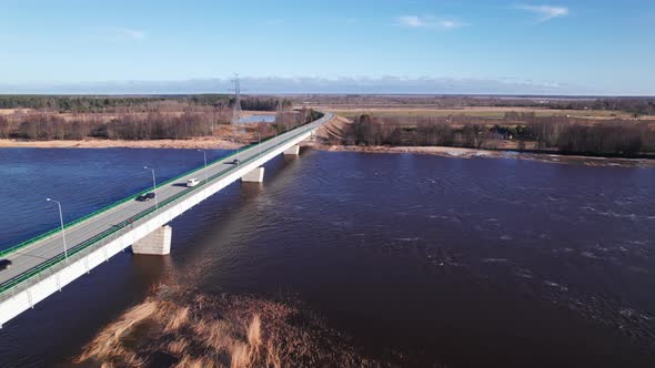 Concrete bridge over burgundy river due to impurities of snow in spring