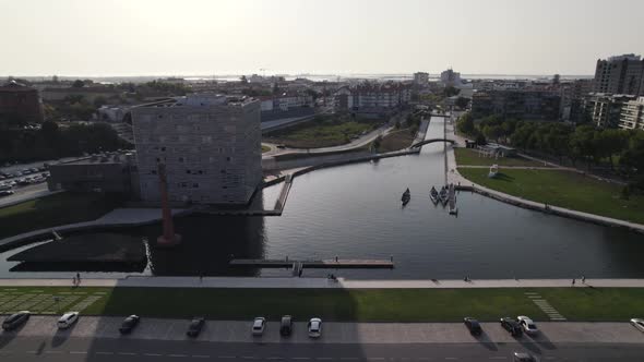 City of Aveiro and majestic old red brick industrial building, aerial fly backward view alt