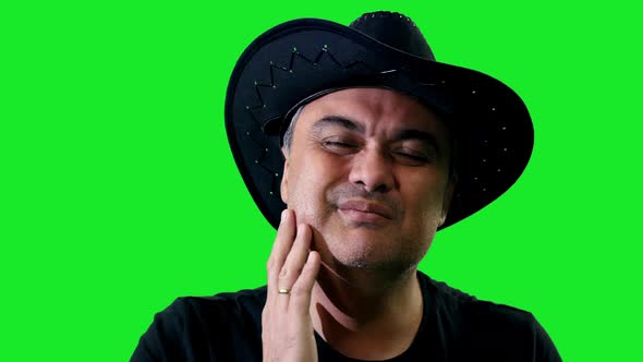 Middle Aged Man In Cowboy Hat Suffering From Toothache On Green Background