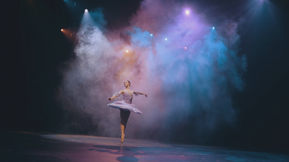 Ballet. Graceful ballerina dancing elements of classical ballet in the beautiful light and smoke