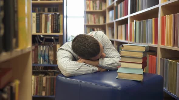 The tired student fell asleep in the library. alt