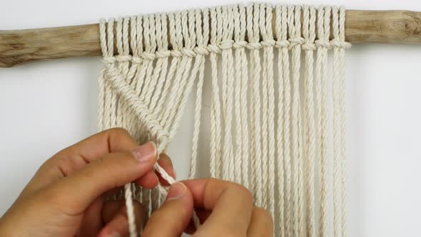 A woman makes home decor in Boho style. Woman making handmade decor weaves macrame alt