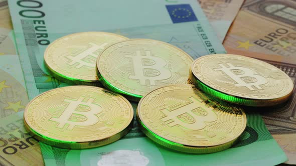 Rotation Coin with Symbol of Cryptocurrency of Bitcoin Lies on Real Euro Banknotes of European Union