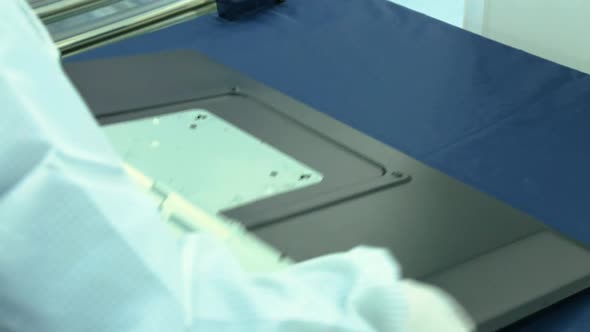 worker is assembling the back of a TV alt