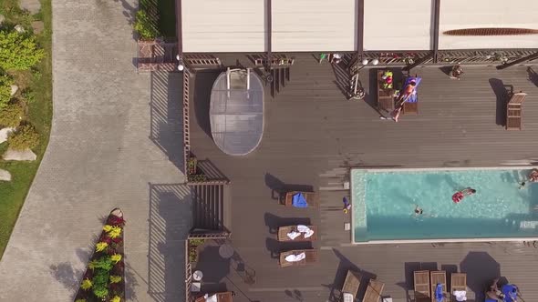 Country recreation center with a pool. People relax, swim and lie 09 alt