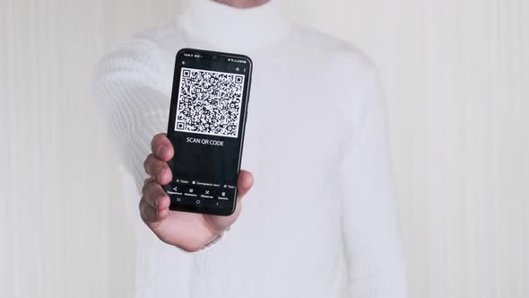 Male Hand Shows QR Code on Smartphone on White Background alt