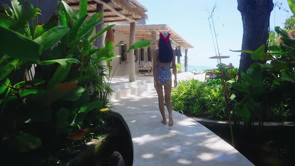Back View Girl In Swimming Suit Walking Alone In Resort On Sunny Day Slow Motion