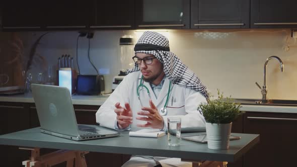 Young Arabic Doctor Making Video Consultation with Patient at Home in the Evening