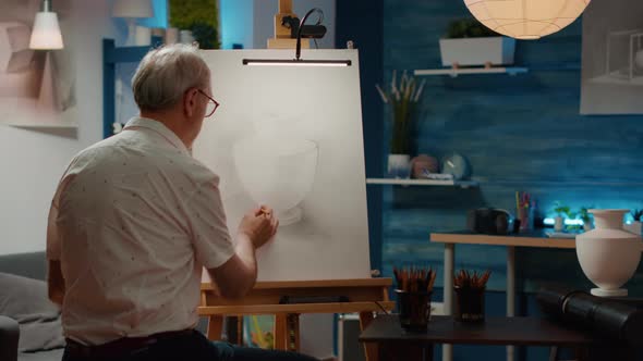 Senior Man Looking at Vase Design Inspiration to Draw Sketch alt