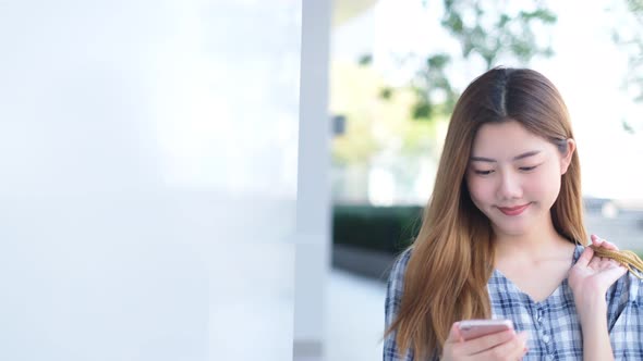 Smiling young Asian woman with shopping colour bags alt