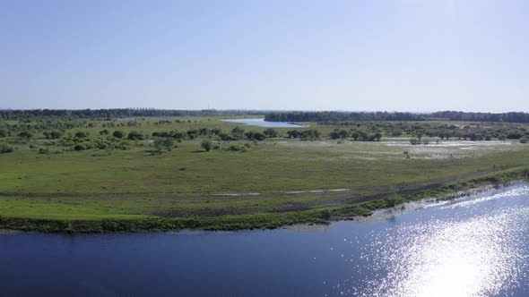 Scenic Aerial View of a River and Green Fields in a Countryside