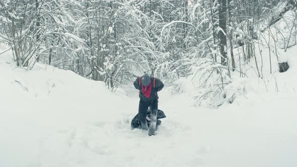 Man Drags a Heavy Makeshift Stretcher Through a Snowy are