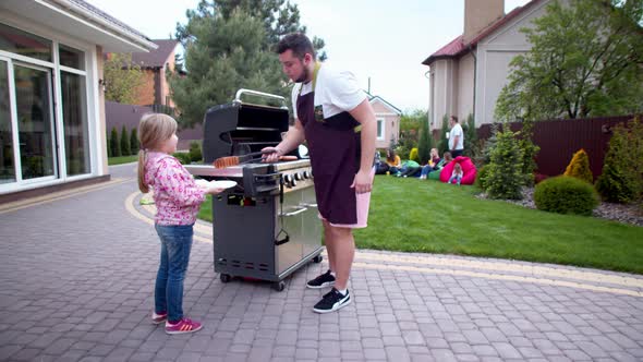 Man Serving Hot Dogs To Young Women