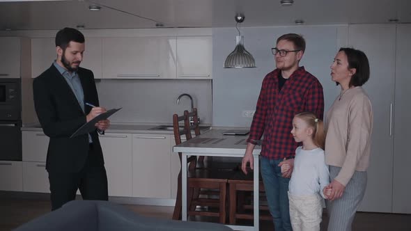 Real Estate Agent Showing New House To Family of Three People