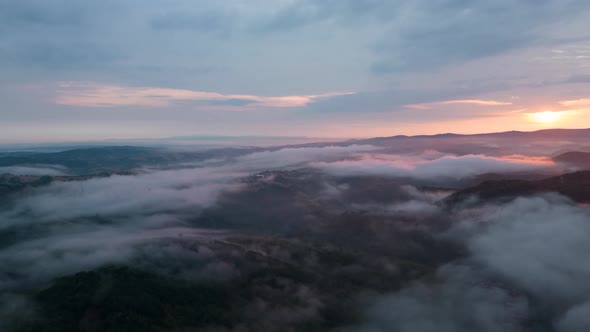 Aerial time lapse of fog over hills after rain, at sunrise