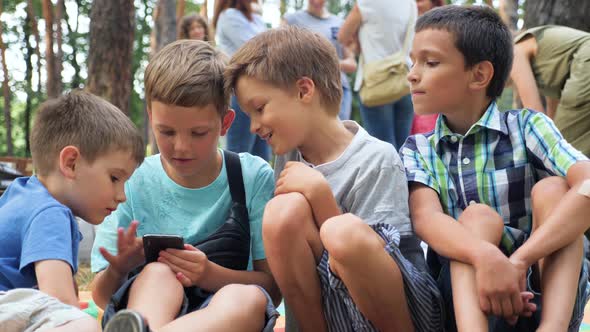 Three Boys Playing Video Game. Three Brothers with Gadget. Faces of Three Boys with Phone Outdoor