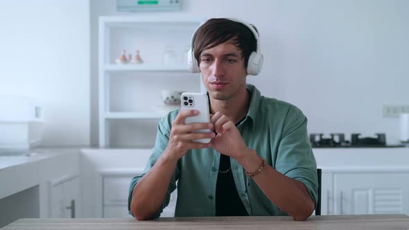 Happy Man in Headphones Looking at Smartphone Celebrate Success Mobile Win Online Bet alt