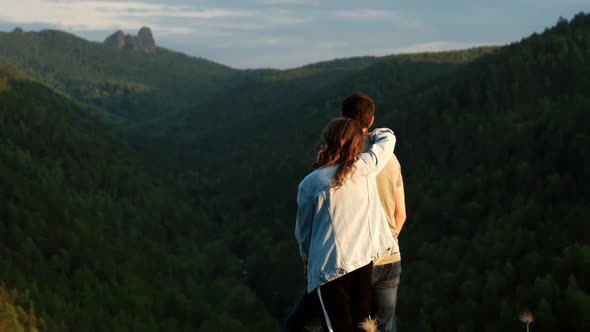 A Young Couple of Lovers on Top of a Mountain
