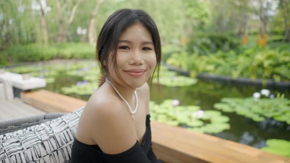 A Girl Sitting in an Open Restaurant Posing for Photo alt