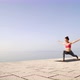 Athletic Woman Wearing Sportswear Doing Yoga on Seaside Boardwalk in the Morning - VideoHive Item for Sale