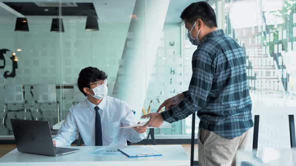 Employees submit documents at their office while wearing masks during the outbreak of the virus.