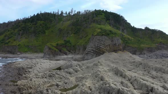 Flying Over Traveler on Cape Stolbchaty, Volcanic Rock Formation on Kunashir island, Russia.