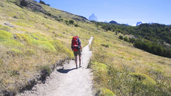 Young woman wearing backpack walking on a trail in Patagonia, Argentina. Trek around Fitz Roy in Los alt