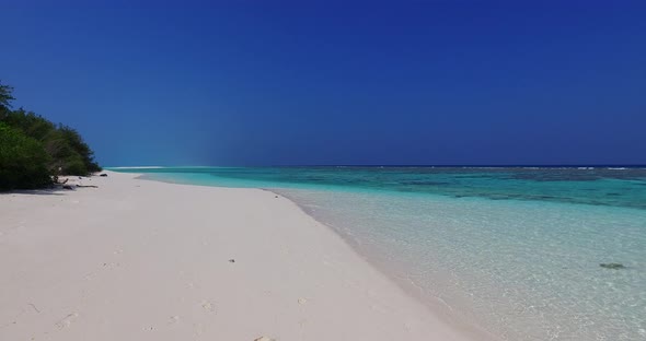 Daytime flying abstract view of a white paradise beach and turquoise sea background in colorful 4K alt