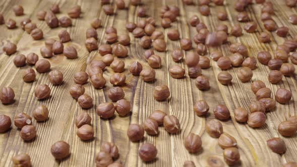 Dried Hazelnuts Lying on a Textured Wooden Table Surface alt