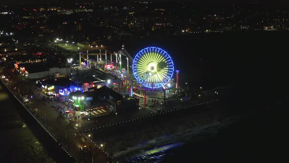 AERIAL: Breathtaking View on Santa Monica Pier at Night with Ferris Wheel and Colorful Lights,  alt