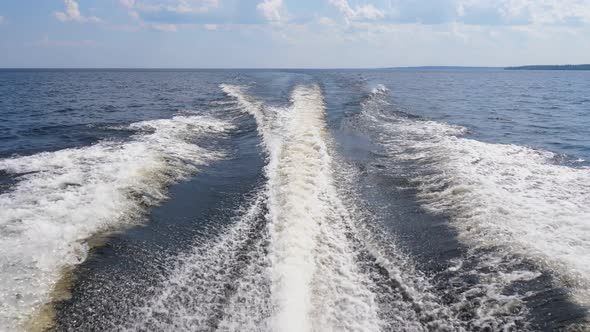 Fast motorboat glide at big lake, look back to wake after watercraft alt