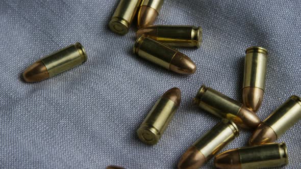 Cinematic rotating shot of bullets on a fabric surface - BULLETS 087 alt