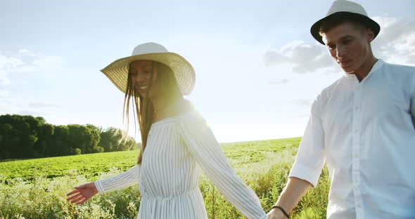 Lovely Couple Walking on Sunset Field