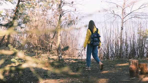 A Tourist Walking in the Woods From Behind