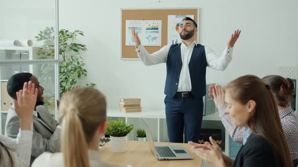 Slow Motion of Cheerful Man Making Report Then Doing Highfive and Dancing While Coworkers Applauding alt