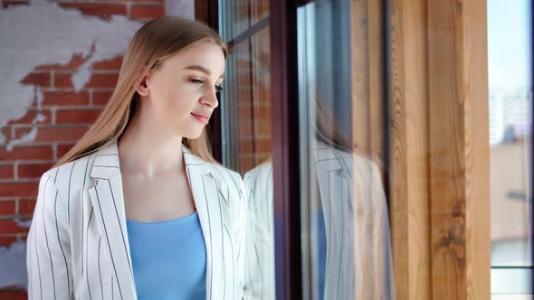 Stylish Young Focused Businesswoman Thinking Looking at Office Window and Dreaming Medium Shot alt