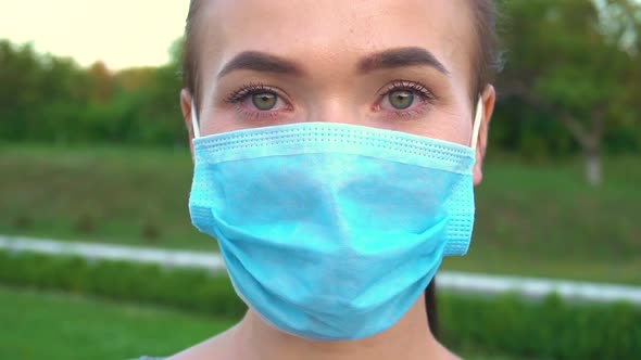 Woman in Protective Medical Mask Looking at Camera.